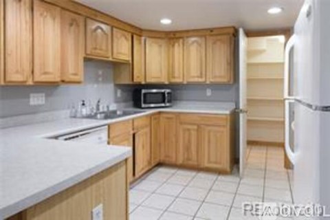 A kitchen with wooden cabinets and a white refrigerator.