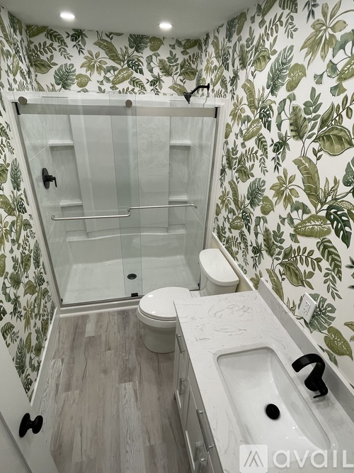 A bathroom with a toilet, sink, and shower.