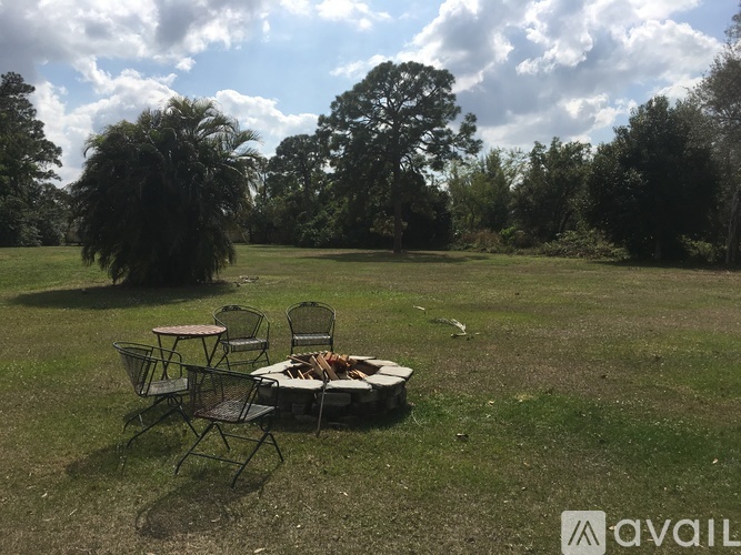 A picnic setup with a table and chairs in a grassy field.