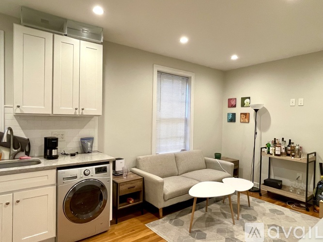 A modern kitchen with a washing machine and a dining table.