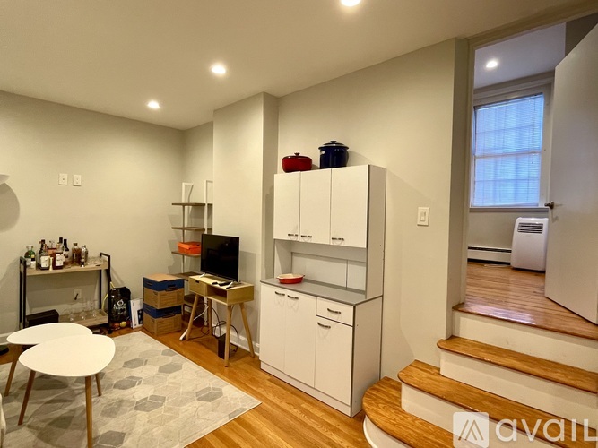 A kitchen with white cabinets and a wooden floor.