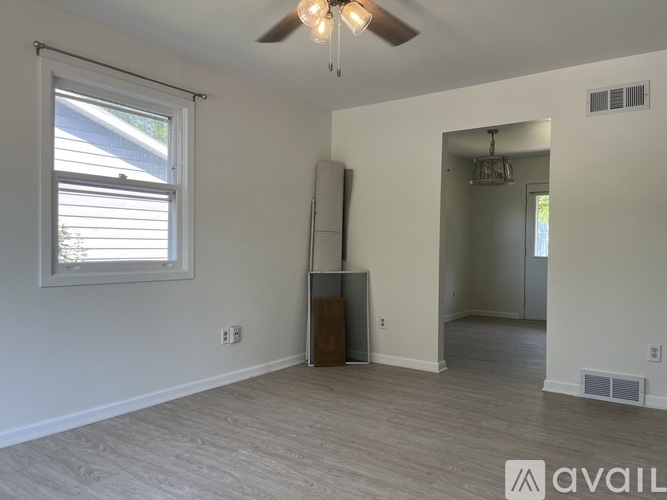 A room with a ceiling fan and a window with blinds.