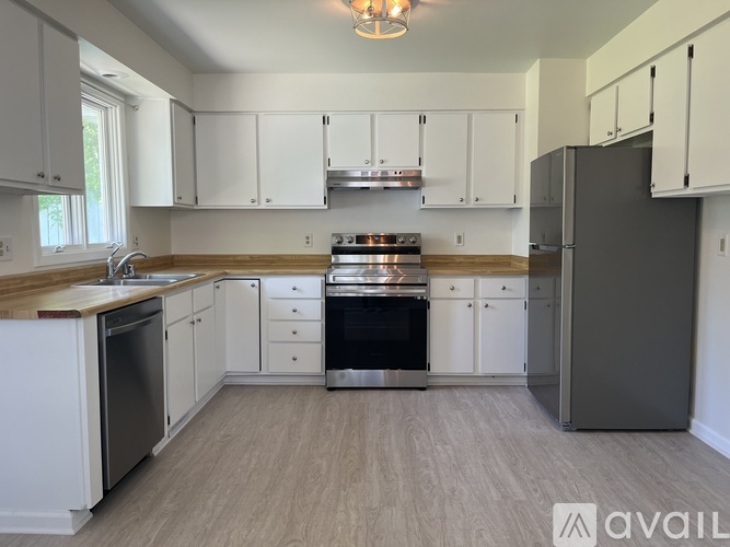 A kitchen with white cabinets and a wooden countertop.