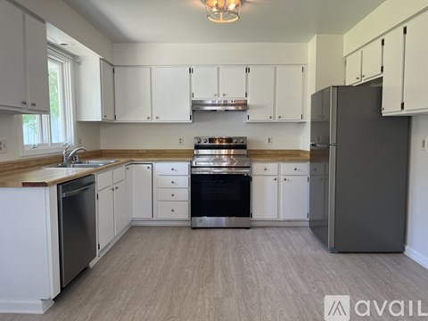 A kitchen with white cabinets and a wooden countertop.