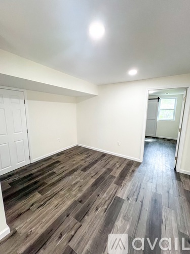 A room with wooden flooring and white walls.