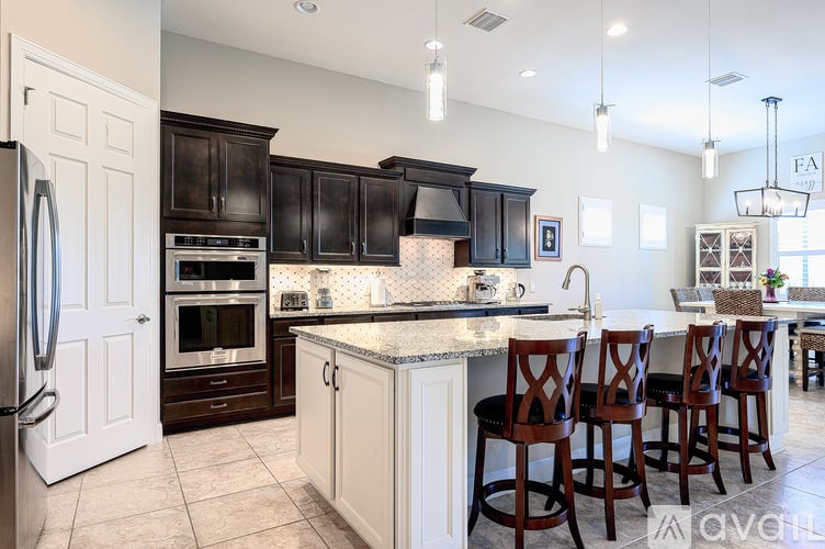 A kitchen with a white refrigerator and black cabinets.