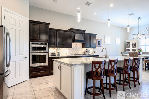 A kitchen with a white refrigerator and black cabinets.