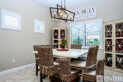 A dining room with a table and chairs.