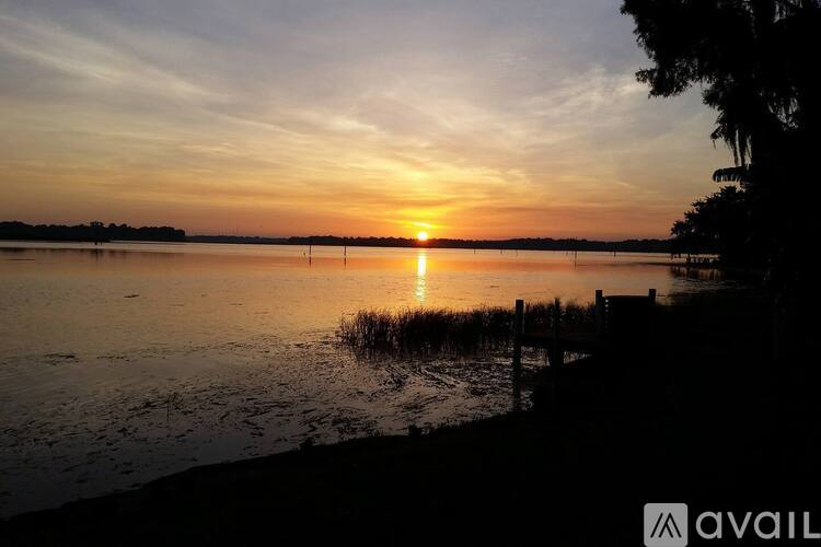 A sunset over a body of water with a dock in the foreground.