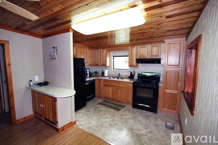 A kitchen with wooden cabinets and black appliances.