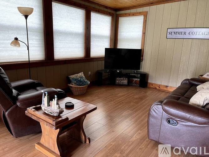 A living room with a brown leather couch and a wooden coffee table.