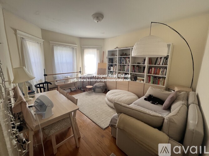 A living room with a couch, a chair, a table, and a bookshelf.