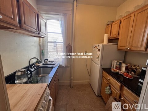A kitchen with wooden cabinets and a white refrigerator.
