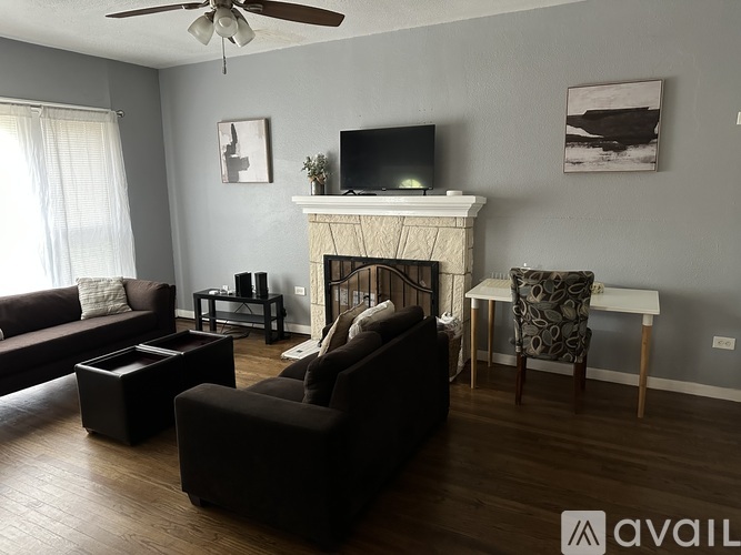 A living room with a fireplace, a couch, a chair, and a television.