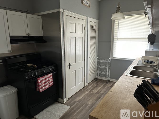 A kitchen with a black stove and white cabinets.