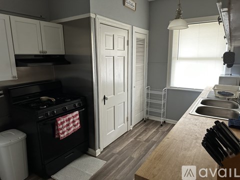 A kitchen with a black stove and white cabinets.