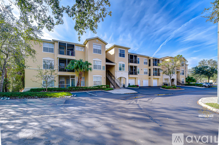 A sunny day at the Brindley Apartments with a clear blue sky and trees in the foreground.