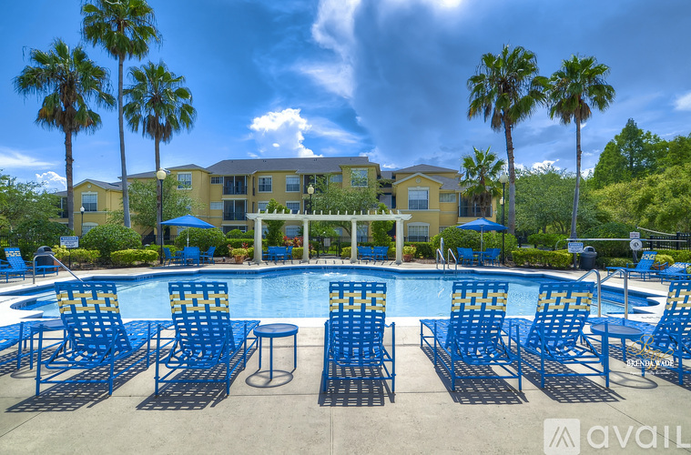 A pool surrounded by blue chairs and palm trees.