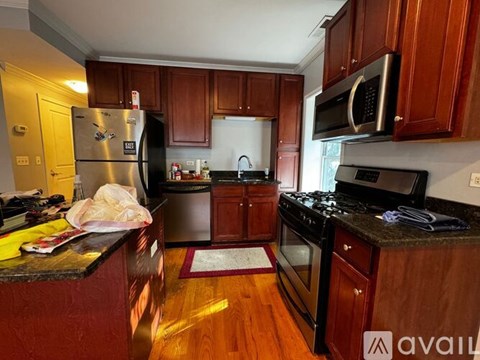 A kitchen with wooden cabinets and a black fridge.