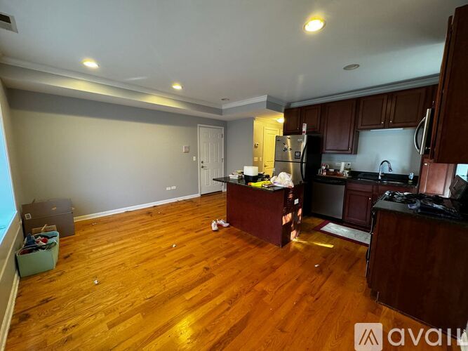 A kitchen with wooden floors and a refrigerator.