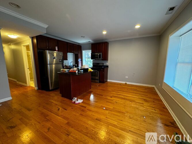 A kitchen with wooden floors and a refrigerator.