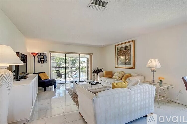 A living room with a white couch and a framed picture on the wall.