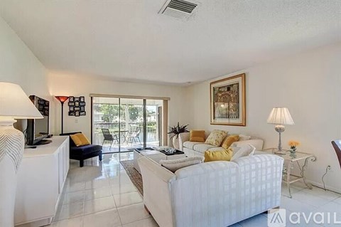 A living room with a white couch and a framed picture on the wall.