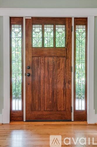 A wooden door with glass panels and a black handle.