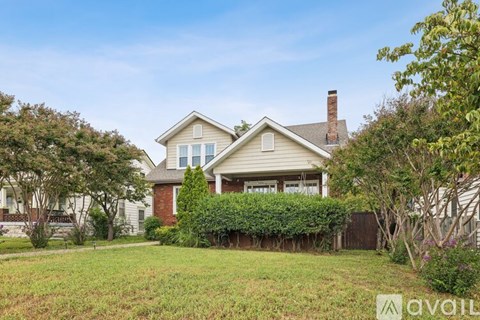 A house with a large front yard and a chimney.
