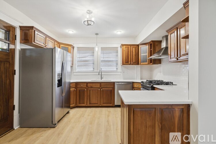 A kitchen with wooden cabinets and a stainless steel refrigerator.