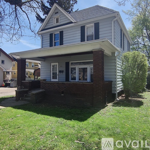 A house with a grey siding and a brick pillar.