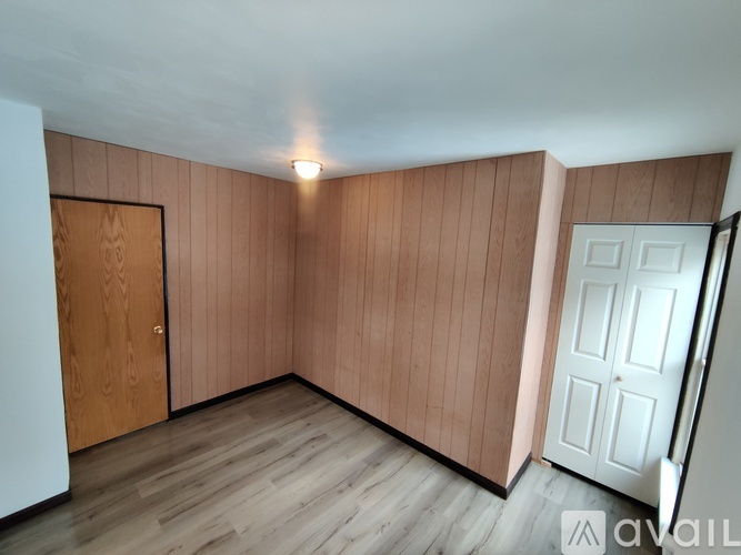 A room with wooden walls and a white door.