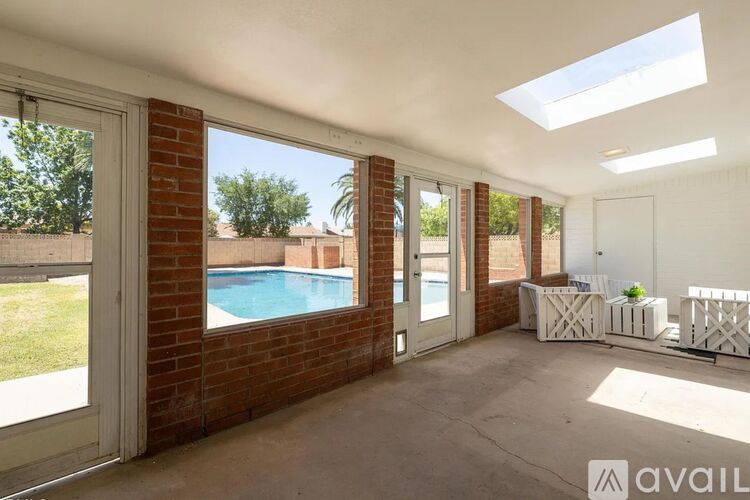A sunny backyard with a pool and a patio area.