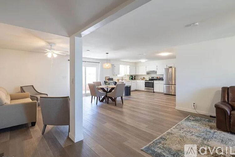 A living room with a couch, chairs, and a dining table.