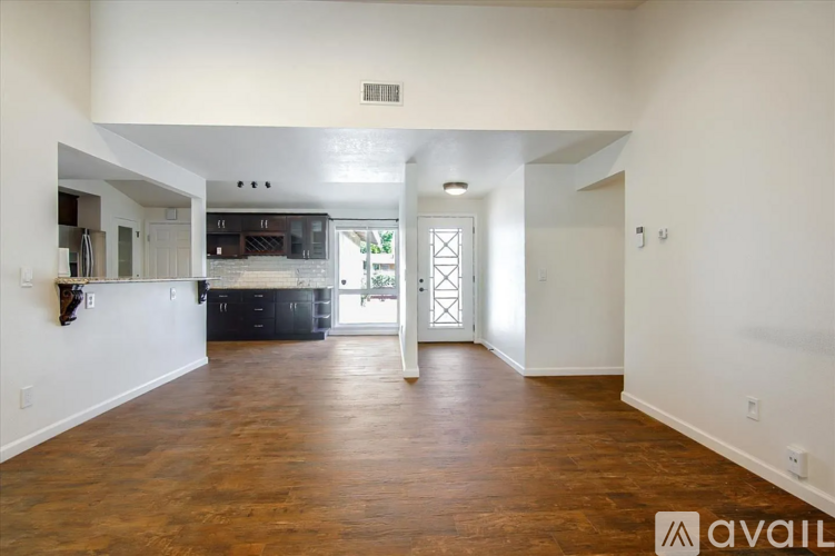 A spacious room with wooden floors and white walls.
