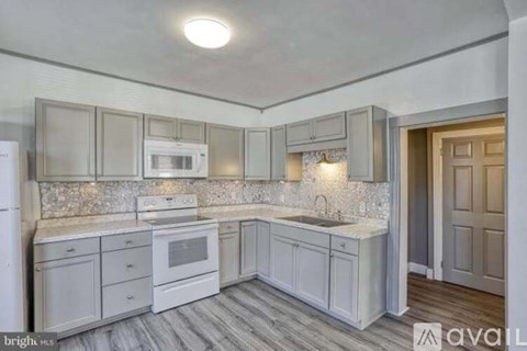A kitchen with white cabinets and a countertop.