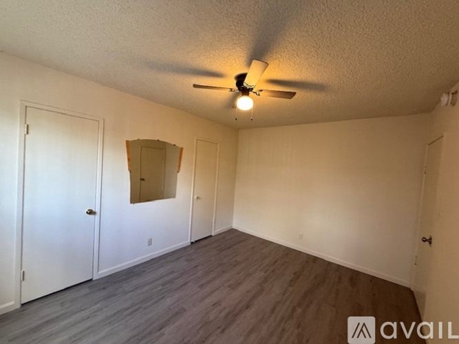 A room with a ceiling fan and a mirror on the wall.