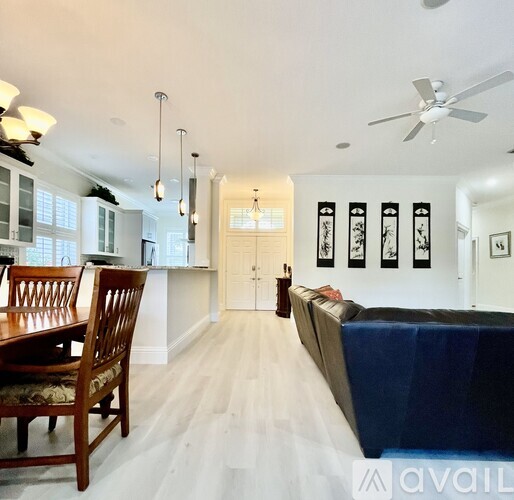 A living room with a couch, a dining table and a kitchen area.
