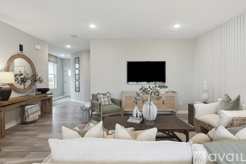 A modern living room with a white sofa and a coffee table with a vase of flowers on it.