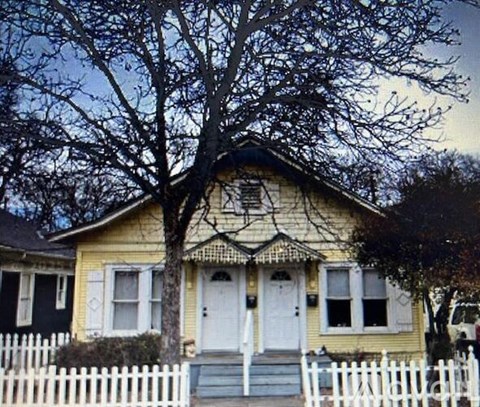 A yellow house with a white picket fence.