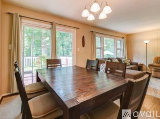 A dining room with a wooden table and chairs.