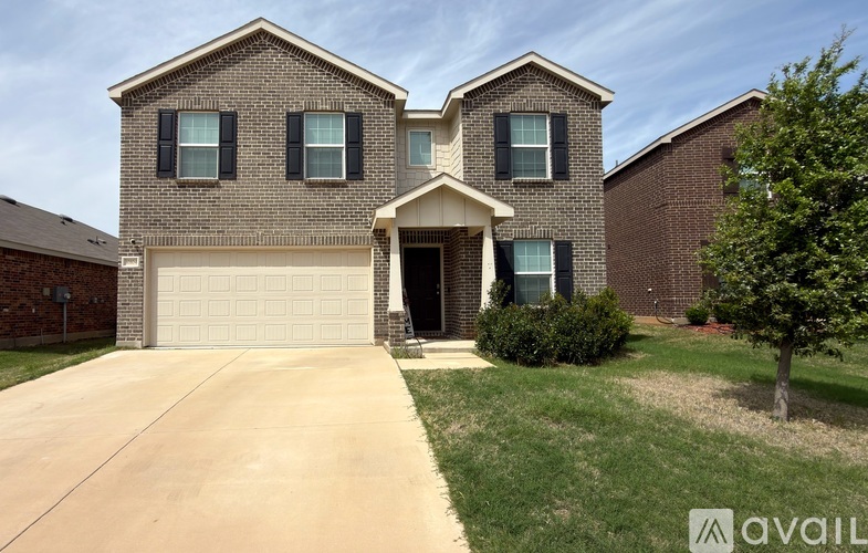 A two-story house with a garage and a driveway.