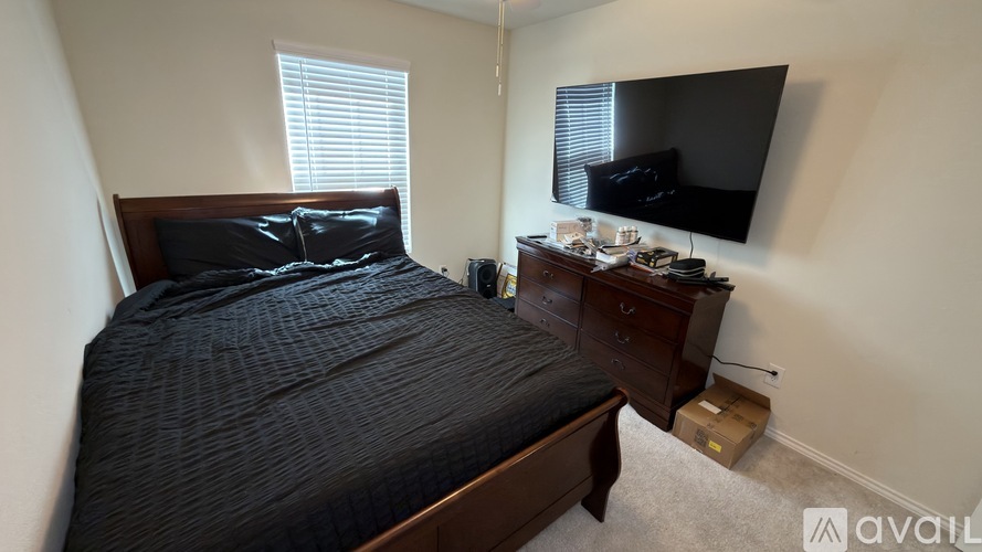 A bedroom with a bed, nightstand, and television.