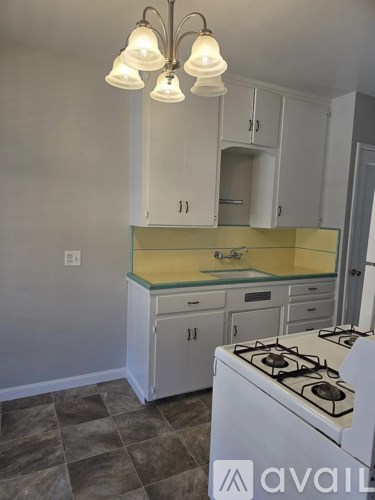 A kitchen with a white stove and cabinets.