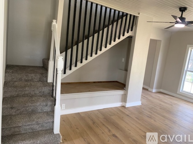 A staircase with a wooden banister and a carpeted runner leads to a second floor.