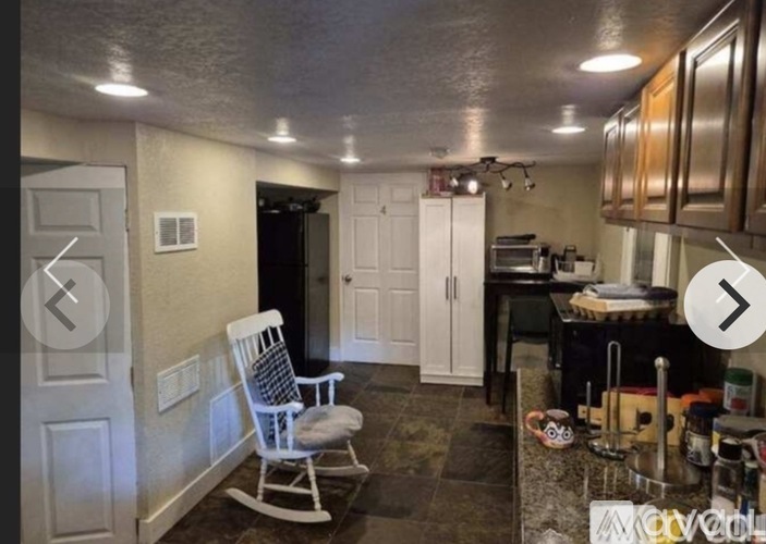 A kitchen with a chair and a table.