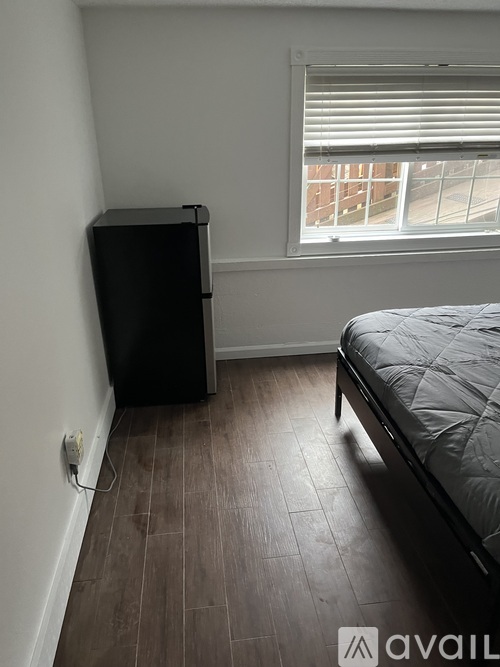 A room with a bed, a wardrobe and a window.