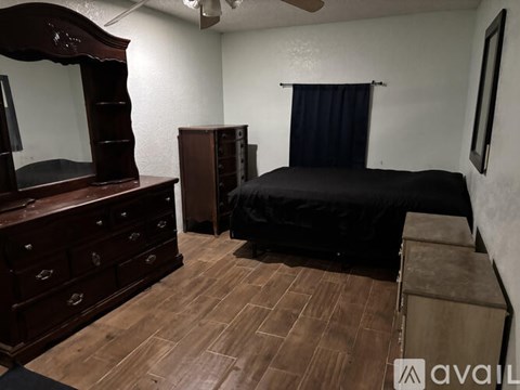 A bedroom with a bed, dresser, and mirror.