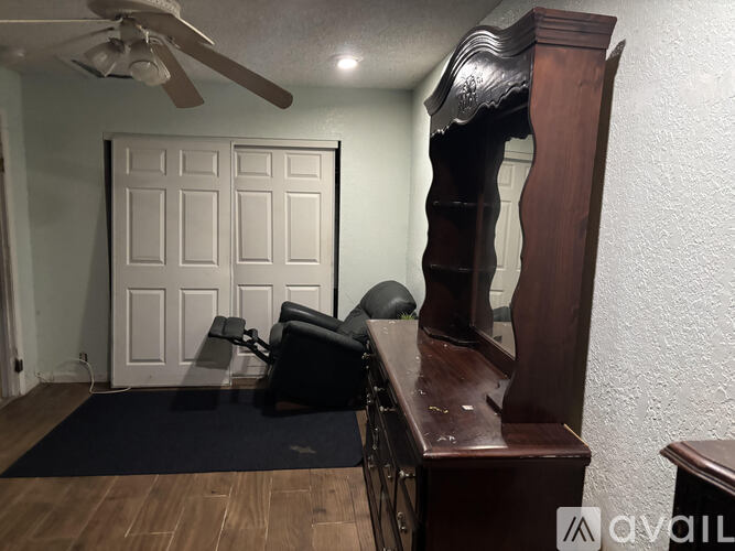 A room with a ceiling fan and a closed door.