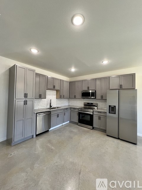 A kitchen with grey cabinets and stainless steel appliances.